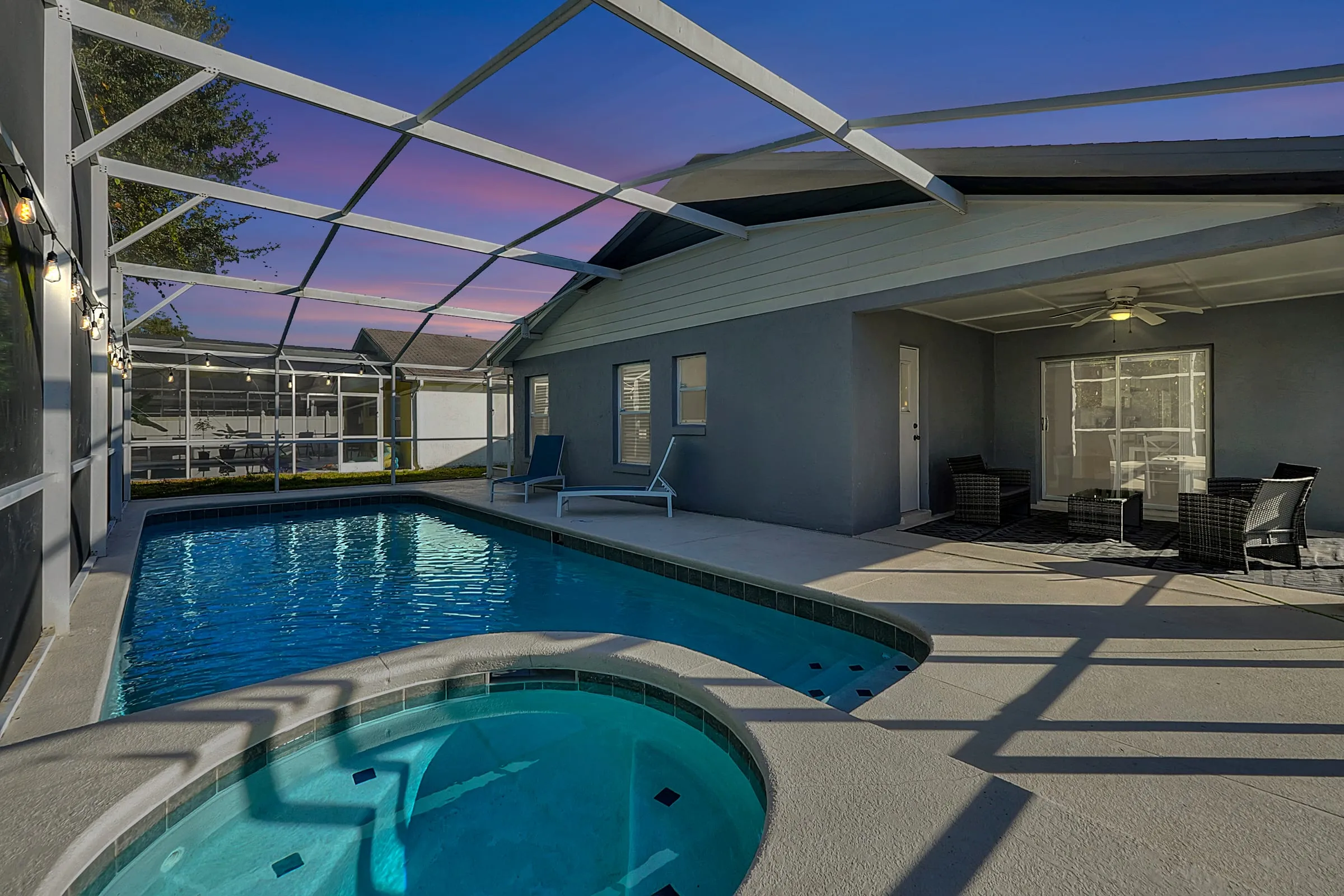 Pool and spa at twilight with deck loungers