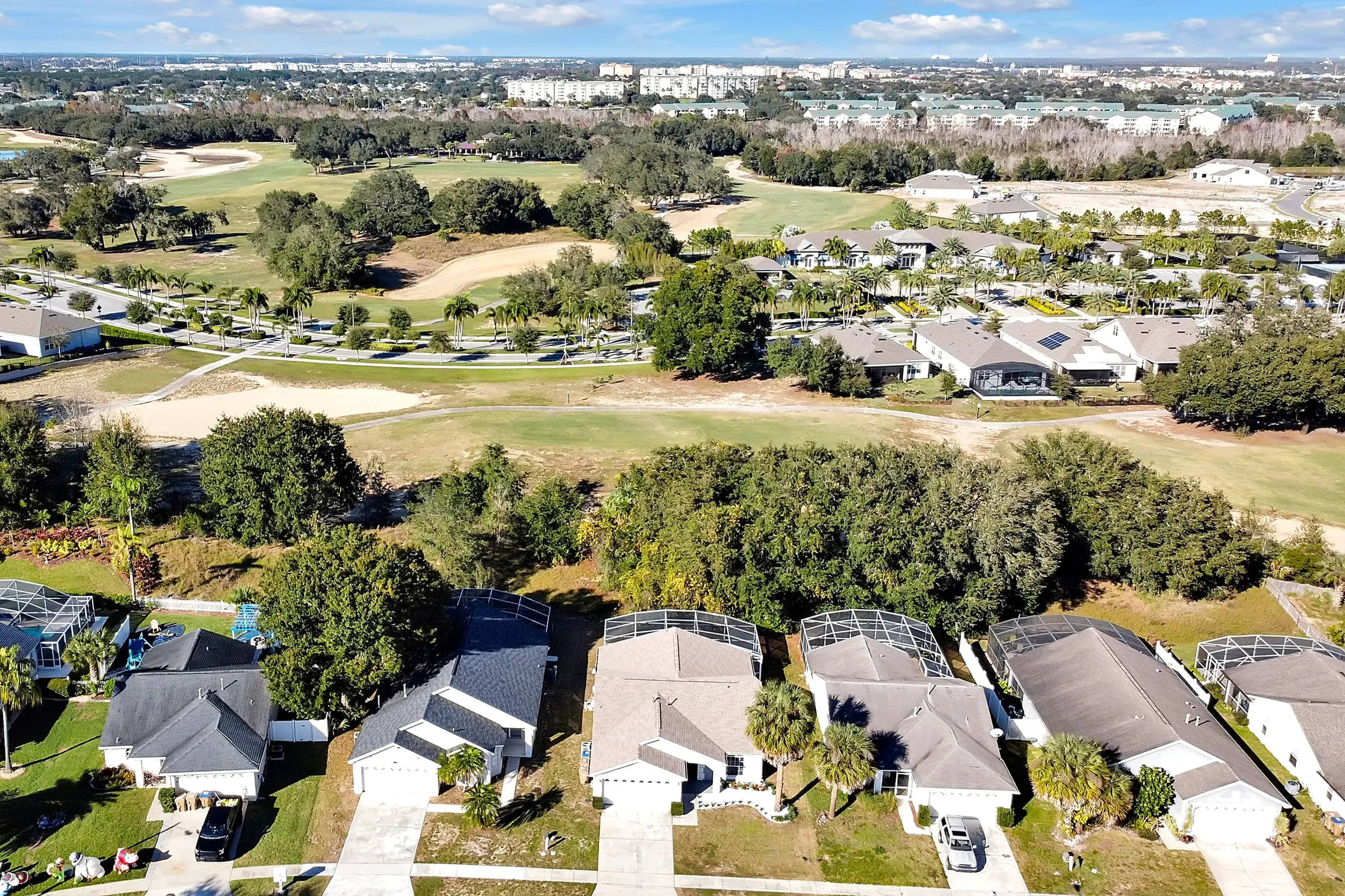 Wide aerial setting the home in its golf-course neighborhood